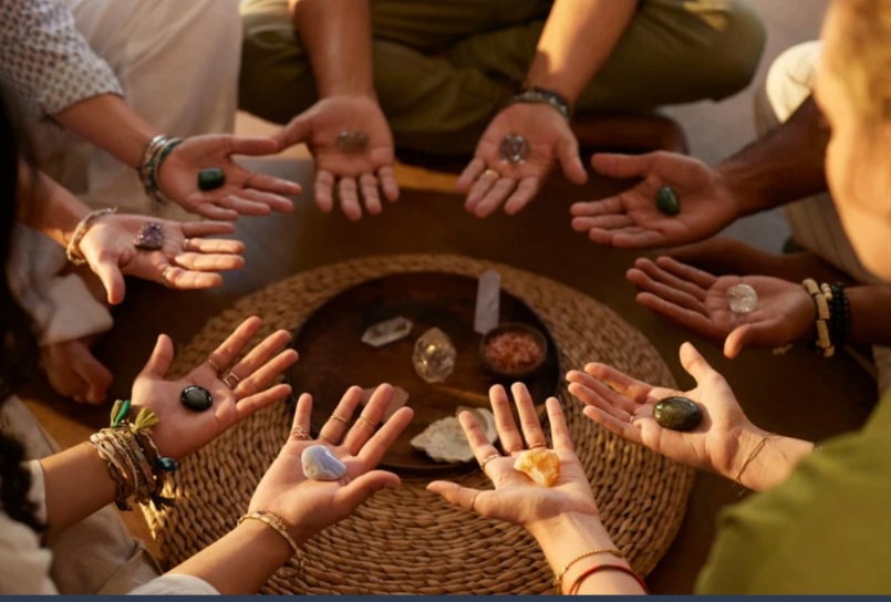 Women holding stones in an open-handed circle
